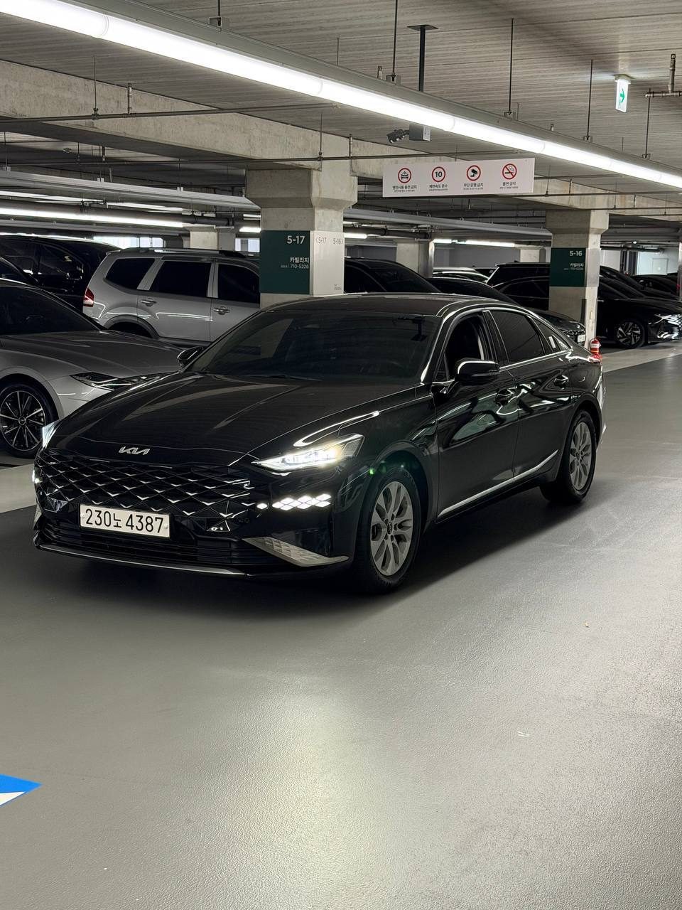 Чёрный седан Kia на подземной парковке в Корее с корейским номером